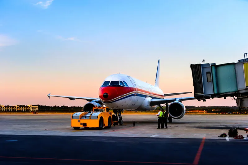 Aeroplano vicino al terminal di un aeroporto al tramonto, pronto per un trasferimento sanitario